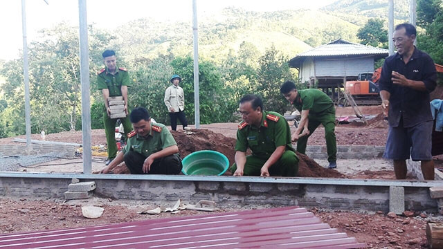 Cán bộ, chiến sĩ Công an huyện Mường Nhé và người dân bản Huổi Hốc chung tay làm nhà cho anh Sủng A Sùng.