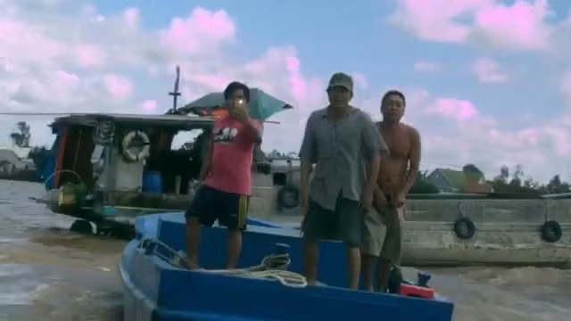 Những người làm thuê của Công ty Khai thác cát Thái Bình dùng ghe sắt áp sát ghe gỗ của anh Thắng. (Ảnh cắt từ clip).