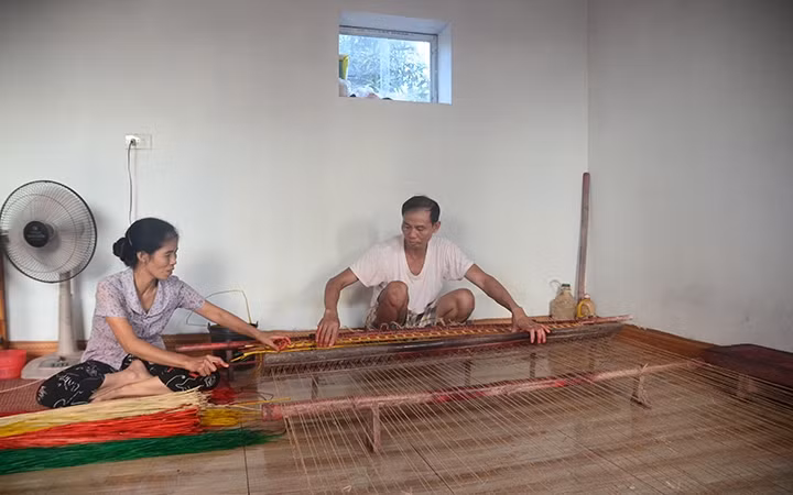 Bà Đinh Thị Hoa văng sợi cho ông Đỗ Văn Dũng dệt chiếu.