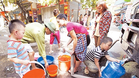 Người dân phố Nguyễn Đổng Chi (quận Nam Từ Liêm, Hà Nội) xếp hàng lấy nước từ xe chở nước sạch. Ảnh: ĐĂNG ANH