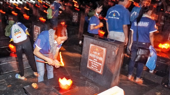 Ðoàn viên, thanh niên huyện Củ Chi thắp nến tri ân các Anh hùng liệt sĩ tại Nghĩa trang liệt sĩ huyện. Ảnh: KIỀU NGÂN