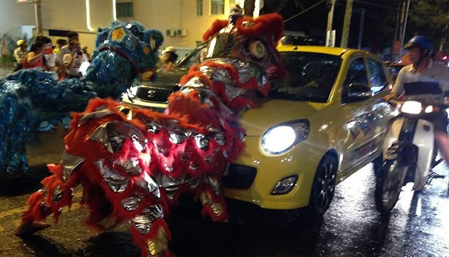 Một đội lân ngang nhiên chặn ô-tô xin tiền trên đường Phan Bội Châu, TP Buôn Ma Thuột.