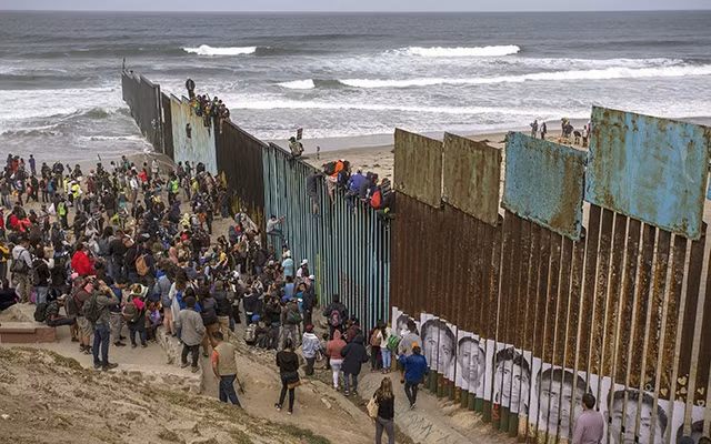 Người di cư tập trung tại khu vực biên giới Mexico giáp Mỹ. Ảnh KTLA