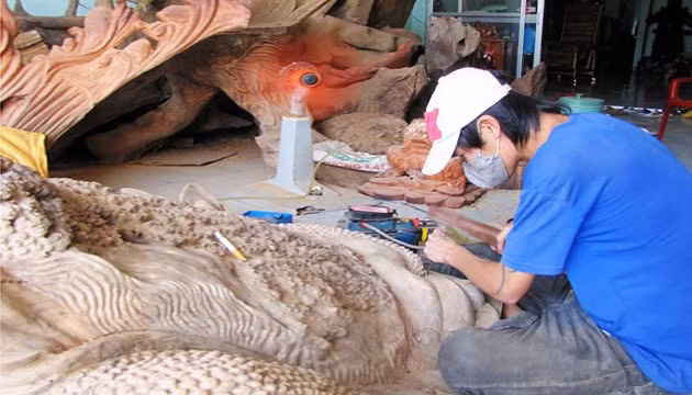 Tạc hình con cóc từ gốc cây gỗ quý.