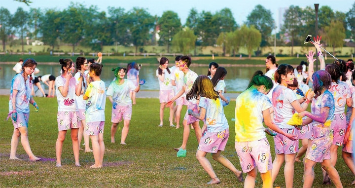 Sinh viên dùng bột mầu bôi lên mặt, quần áo để tạo hình chụp ảnh, nhuộm loang mầu Công viên Yên Sở.