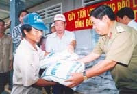 Thượng tá Phạm Ngọc Trọng
cùng Quỹ Tấm lòng vàng
Lao Động tặng gạo cho 96
hộ nghèo mùa lũ năm 2001.