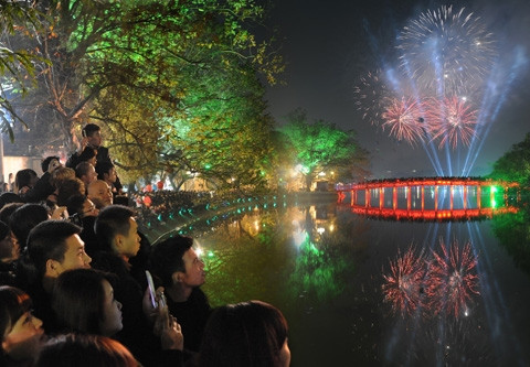 Ðón chào năm mới Giáp Ngọ 2014, nhiều người dân Thủ đô Hà Nội đổ về khu vực quanh hồ Hoàn Kiếm vui Xuân và chiêm ngưỡng màn bắn pháo hoa vào thời khắc giao thừa.  Ảnh: TRẦN HẢI