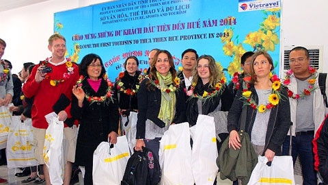 Ngành du lịch TT-Huế đón và tặng hoa chúc mừng 20 vị khách đầu tiên xông đất năm mới 2014.