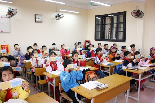 Học sinh Trường tiểu học Giang Biên (quận Long Biên) nhận thẻ bảo hiểm tự nguyện của Công ty Bảo Việt Hà Nội.