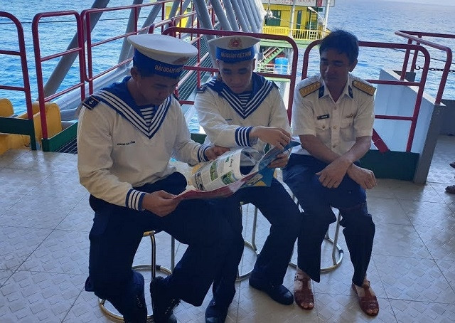 Thời gian nghỉ ngơi, các chiến sĩ nhà giàn cập nhật thông tin qua sách, báo. (Ảnh: QUANG HUY)