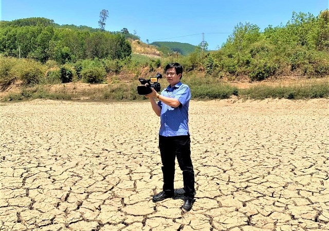 Phóng viên Báo Nhân Dân tác nghiệp ở vùng khô hạn xã Cư Pui, huyện Krông Bông, tỉnh Đắk Lắk.