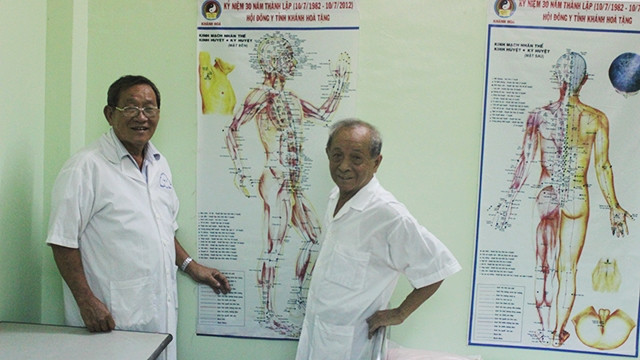 Bác sĩ Đồng và lương y Nguyễn Trung Kiên bên phác đồ điều trị đông y miễn phí cho người nghèo, cựu chiến binh khó khăn.