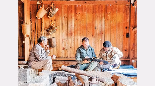 Pierre Morère cùng những người già trong buôn làng Đạ Sar xem những tư liệu về gia đình anh.