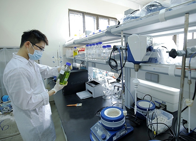 Sinh viên Khoa Kỹ thuật quản lý môi trường (Trường đại học Bách khoa Hà Nội) thực hành nghiên cứu với máy cân phân tích.