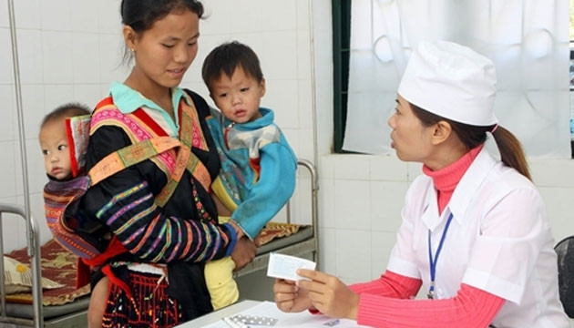 Nhân viên Trạm y tế xã Hừa Ngài, huyện Mường Chà (Điện Biên) hướng dẫn người dân sử dụng thuốc đúng cách trong điều trị bệnh cho trẻ em. Ảnh: DƯƠNG NGỌC