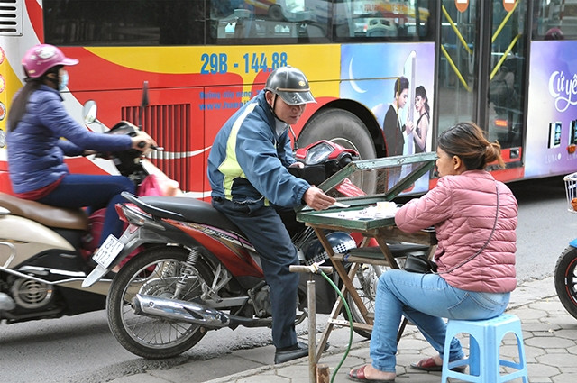 Mua bán vé xổ số trên vỉa hè phố Ngô Quyền (Hà Nội). Ảnh: NGUYỄN ĐĂNG
