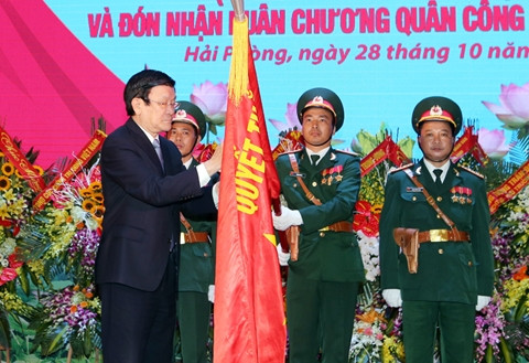 Chủ tịch nước Trương Tấn Sang gắn Huân chương Quân công hạng nhất lên lá cờ truyền thống của Quân khu 3. Ảnh: NGUYỄN KHANG (TTXVN)
