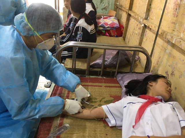 Cán bộ Trung tâm Kiểm soát bệnh tật khám, lấy mẫu bệnh phẩm học sinh bị nghi nhiễm cúm.