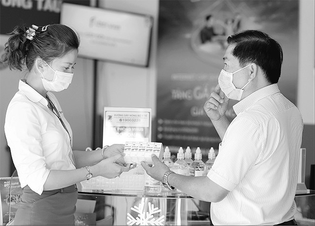 Nhân viên VNPT hướng dẫn khách hàng sử dụng dung dịch diệt khuẩn.
