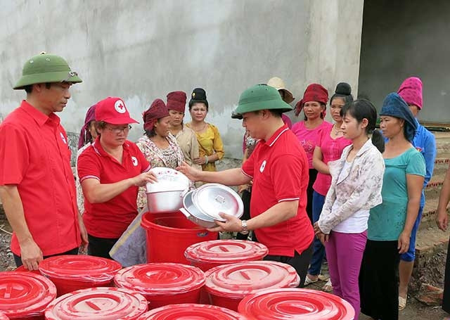 Cán bộ Hội Chữ thập đỏ Việt Nam, Hội Chữ thập đỏ tỉnh Sơn La trao đồ dùng sinh hoạt hỗ trợ người dân thôn Hua Nậm, xã Nặm Păm, huyện Mường La (Sơn La). 