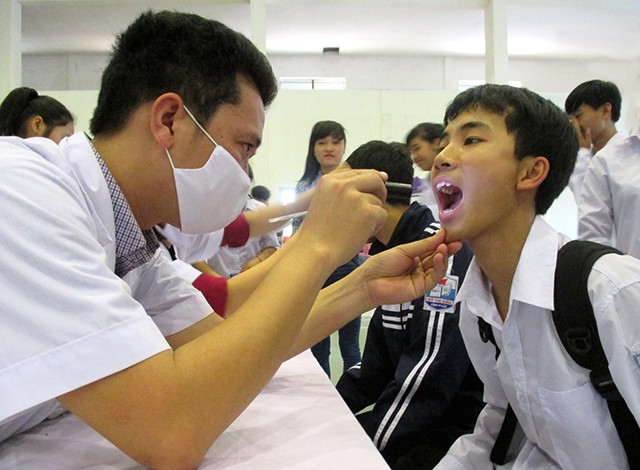 Y, bác sĩ Bệnh viện đa khoa TP Vĩnh Yên khám bệnh cho học sinh Trường THPT Võ Thị Sáu (Vĩnh Phúc). Ảnh: TRỌNG HÙNG