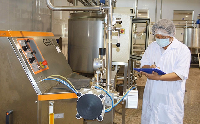 Cán bộ Công ty Chế biến dừa Lương Quới kiểm tra dây chuyền sản xuất.