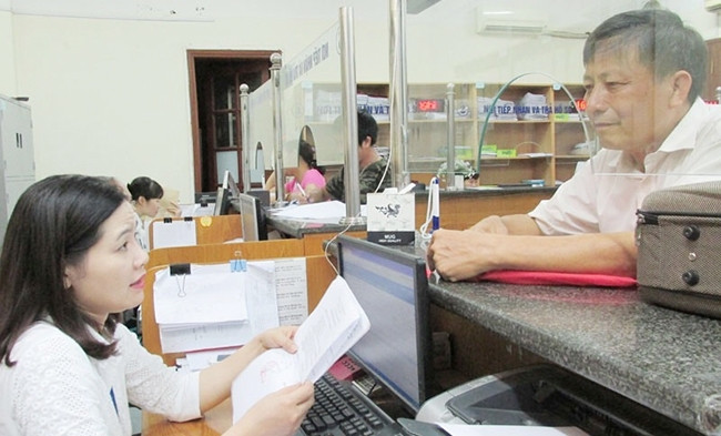 Người lao động làm thủ tục hành chính tại Bảo hiểm xã hội TP Hà Nội. Ảnh: THÙY LINH