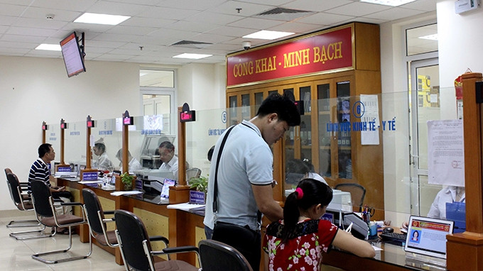 Người dân đến làm thủ tục hành chính tại bộ phận một cửa của UBND quận Hoàn Kiếm. Ảnh: ANH CAO