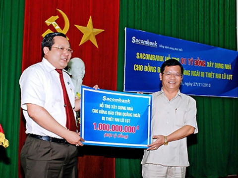 Chủ tịch Ủy ban MTTQ Việt Nam tỉnh Quảng Ngãi Lê Viết Chữ (bên phải) tiếp nhận một tỷ đồng từ Tổng Giám đốc Sacombank Phan Huy Khang.