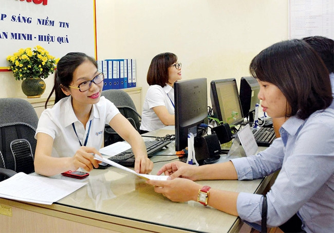 Nhân viên phòng giao dịch của EVNHANOI hướng dẫn khách hàng thực hiện thủ tục thanh toán hóa đơn tiền điện.