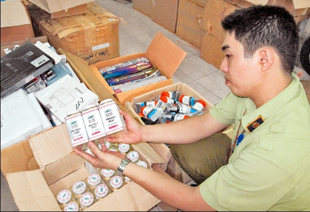 Cán bộ Chi cục Quản lý thị trường thành phố Hồ Chí Minh thu giữ lô hàng không rõ nguồn gốc, xuất xứ lưu hành trên thị trường. Ảnh: minh thoa