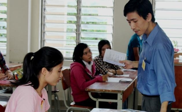 Cán bộ coi thi kiểm tra, phát thẻ dự thi cho thí sinh tại điểm thi ĐH Đà Nẵng.