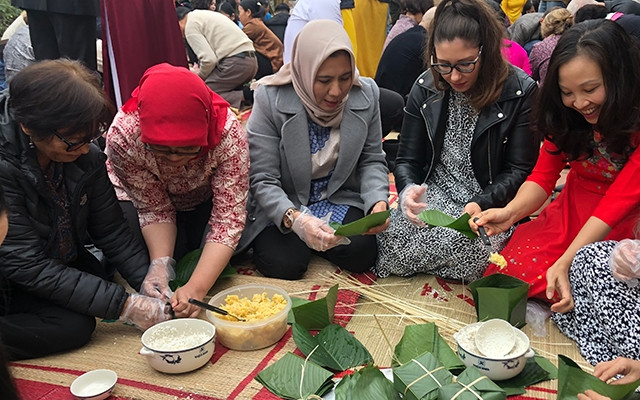 Các cán bộ ngoại giao nước ngoài thi gói bánh chưng.