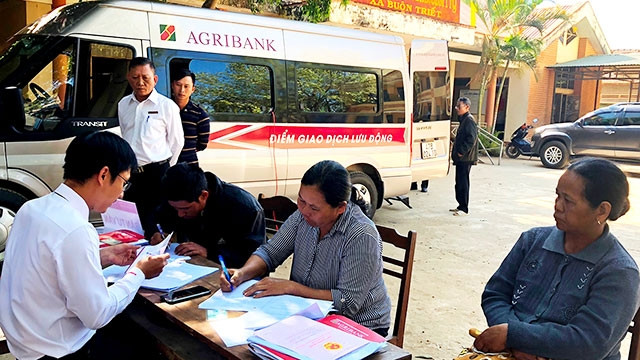 Một phiên giao dịch tại điểm giao dịch lưu động bằng ô-tô chuyên dùng của Agribank tại xã Buôn Triết, huyện Lắk.