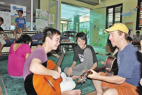 Tình nguyện viên nước ngoài dạy guitare cho trẻ em. Ảnh: DAVID CAMERON