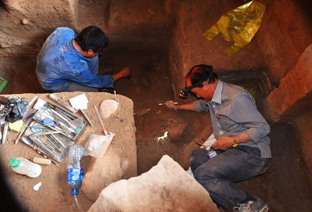 Các nhà khoa học tìm kiếm di vật tại hố khai quật hang C6-1. Ảnh: NGUYỄN PHƯỢNG