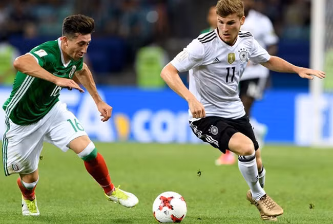 Pha tranh bóng giữa cầu thủ đội tuyển Đức (áo trắng) và đội tuyển Mê-hi-cô.