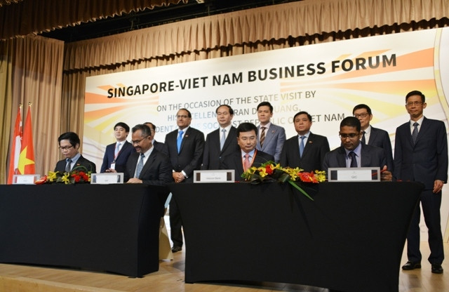 Lễ ký giữa Vietcombank và GIC (bàn ký bên phải) và giữa VCCI với Liên đoàn doanh nghiệp Singapore (bàn ký bên trái).
