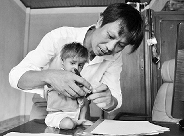 Thầy giáo Đặng Văn Cương hướng dẫn học sinh K'Rể tập viết.