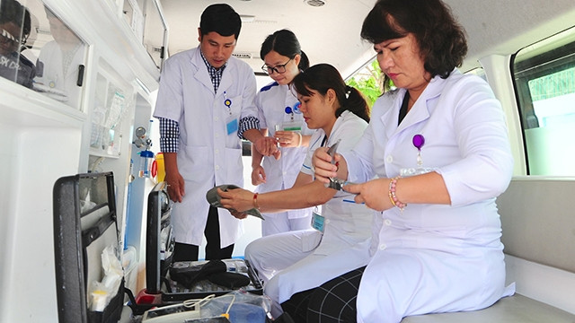 Bác sĩ Phạm Thị Ánh Hồng (bên phải) kiểm tra trang thiết bị y tế trên xe cứu thương 115.