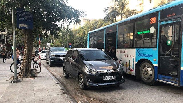 Xe ô-tô dừng đỗ lấn chiếm nhà chờ xe bus tại số 106 phố Nguyễn Khuyến. Ảnh: VÂN NHI
