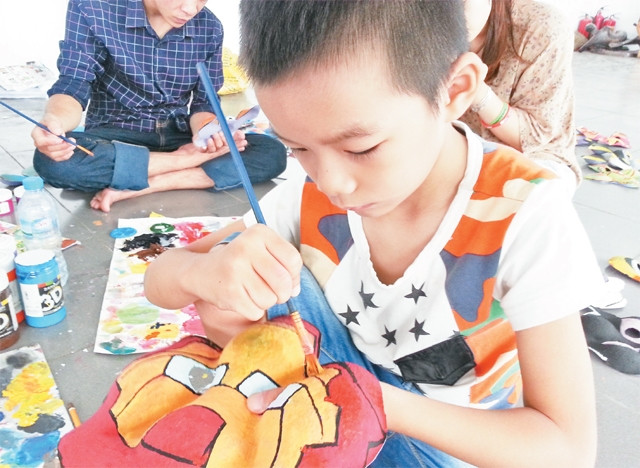 Đỗ Đắc Duy - Học sinh lớp 2A3 Trường tiểu học Đại Mỗ (Hà Nội) say sưa tô mầu cho mặt nạ.