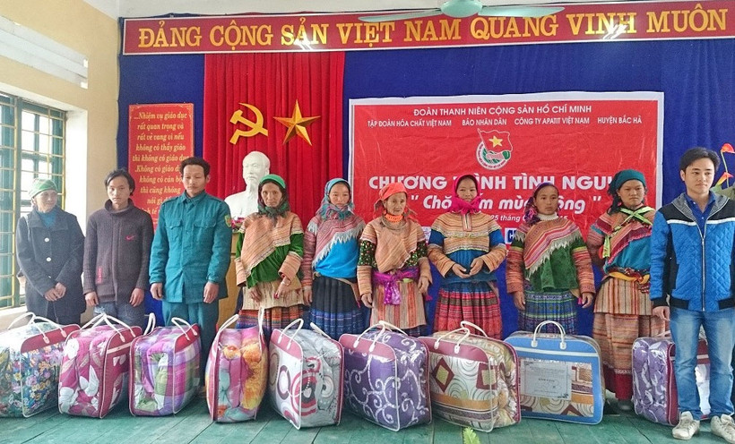 Đại diện các hộ gia đình chính sách xã Lùng Phình, huyện Bắc Hà (Lào Cai) nhận quà do Đoàn Thanh niên Báo Nhân Dân trao tặng. Ảnh: HOÀNG CHIẾN