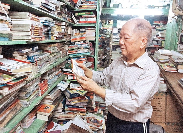 Ông Luy, chủ quán sách số 5 Ðinh Lễ giới thiệu sách với bạn đọc.