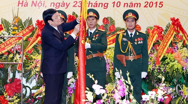 Chủ tịch nước Trương Tấn Sang gắn Huân chương Quân công hạng nhất lên Quân kỳ Quyết thắng của Tổng cục Tình báo Quốc phòng Việt Nam. Ảnh: NGUYỄN KHANG (TTXVN)