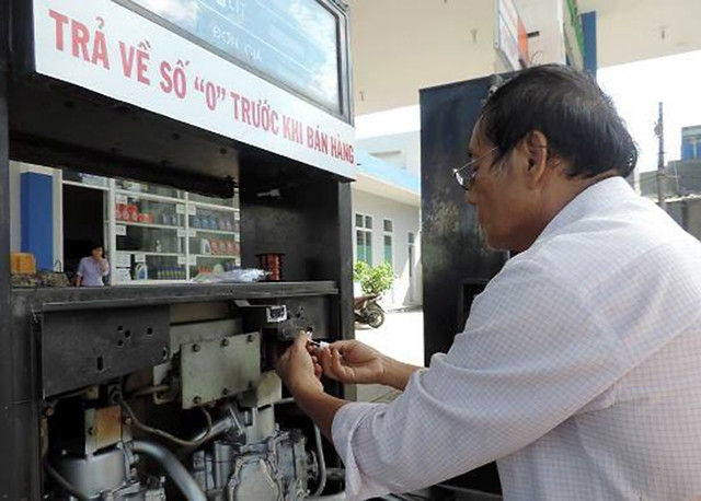 Dán tem niêm phong đồng hồ đếm tổng các cột đo tại cửa hàng xăng dầu số 5, TP Quy Nhơn, tỉnh Bình Định.