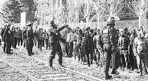 Cảnh sát ngăn chặn dòng người di cư đổ về TP cảng Ca-le (Pháp) để tìm cách vào Anh. Ảnh AP