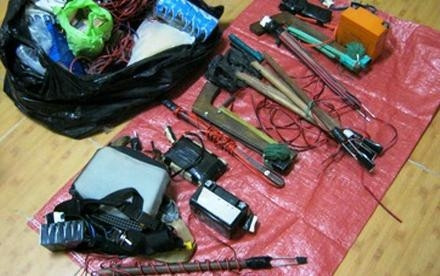 Tang vật của “cẩu tặc” gồm bình ắc-quy, dây điện, và súng tự chế với đinh chĩa sắt nhọn dùng để giết chó.