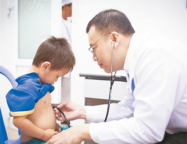PGS, TS, BS Nguyễn Hoàng Định (Bệnh viện Đại học Y dược TP Hồ Chí Minh) khám tim cho trẻ em trong chuyến từ thiện vùng xa.