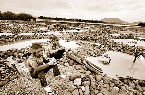 Một đoạn sông Ba sau đập thủy điện An Khê - Ka Nak đã trở nên cạn kiệt. Trong ảnh: Một cặp vợ chồng đãi cát tìm vàng giữa sông Ba đoạn thuộc địa phận thị trấn Củng Sơn, huyện Sơn Hòa, tỉnh Phú Yên. Ản